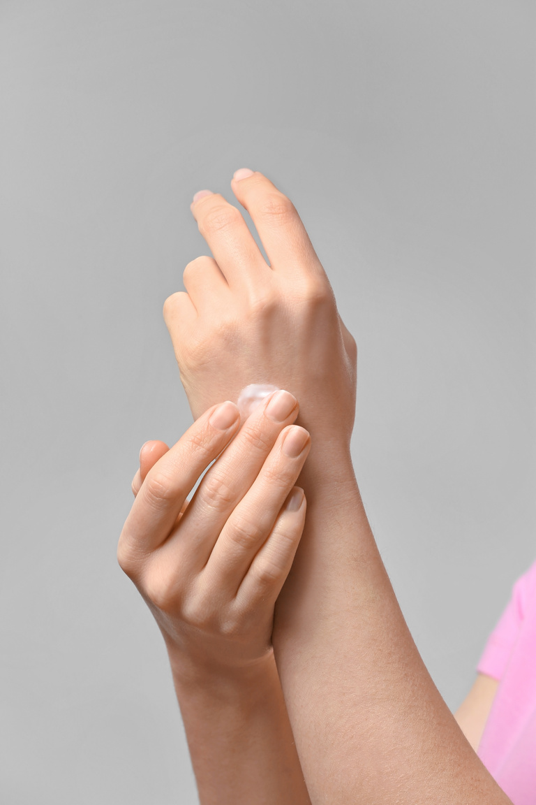 Woman Applying Body Cream onto Hands, Closeup